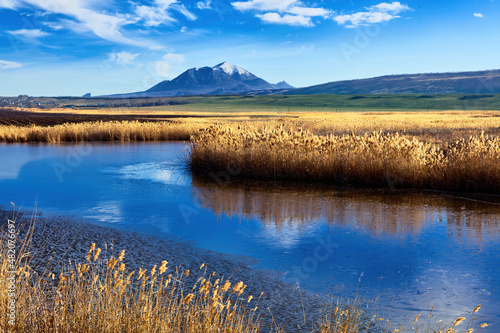 Nameless lake on the background of blue sky and mountains of Caucasian Mineral waters. The Bull and Beshtau mountains  the laccoliths of the North Caucasus. Winter landscape