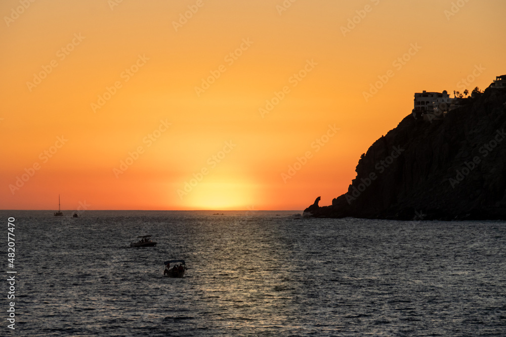 orange sunset over ocean and cliffs