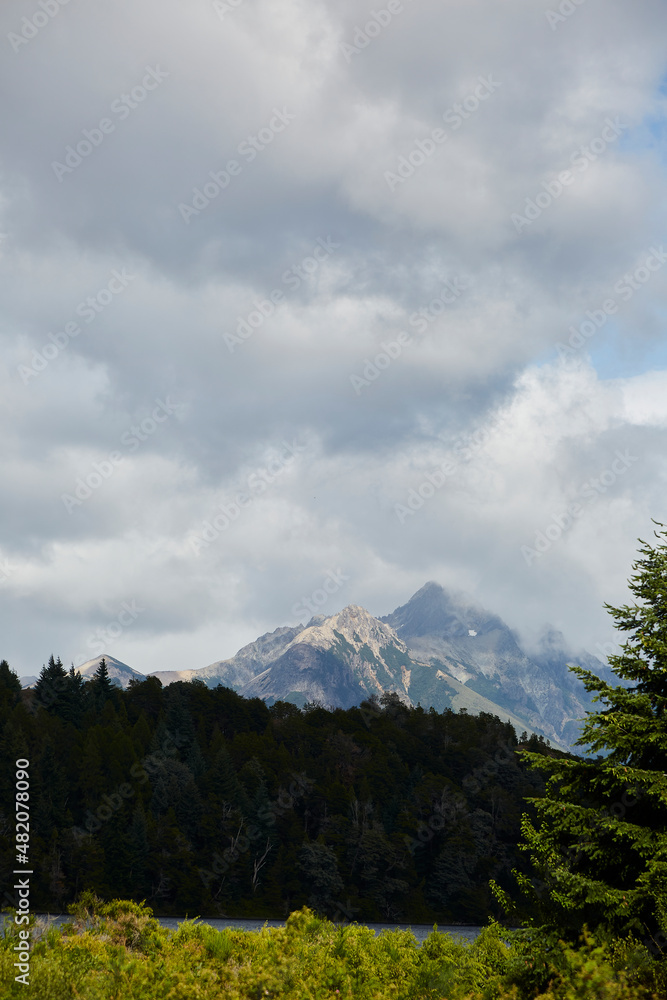 Mountain summit, peak or summit of a mountain in the Argentine Patagonia. Mountain of the Andean Cordillera. Vegetation in front and sky with many clouds. Mountain summit, peak or summit of a mountain in the Argentine Patagonia. Mountain of the Andean Cordillera. Vegetation in front and sky with many clouds.