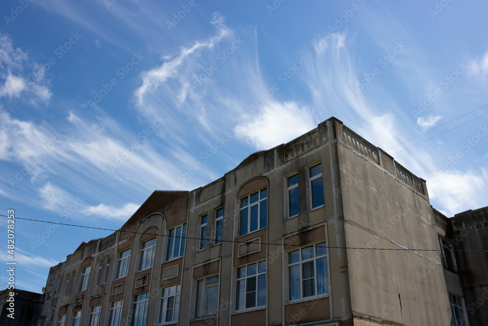 Above the house is a beautiful sky background. Unusual cirrus clouds in a blue sky