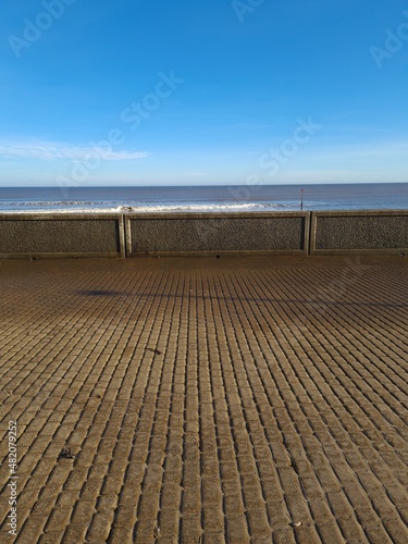 Hornsea beach in East Yorkshire in England UK on a sunny day with stone floor in the main focus