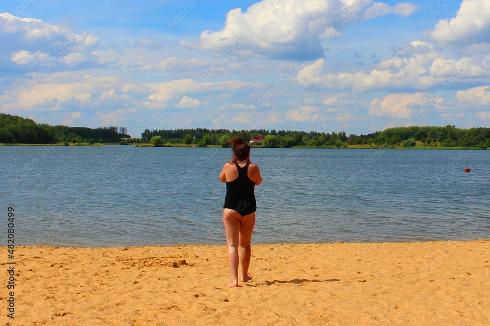 Minsk. Belarus. June 15, 2019. A girl in black clothes on the beach by the pond.