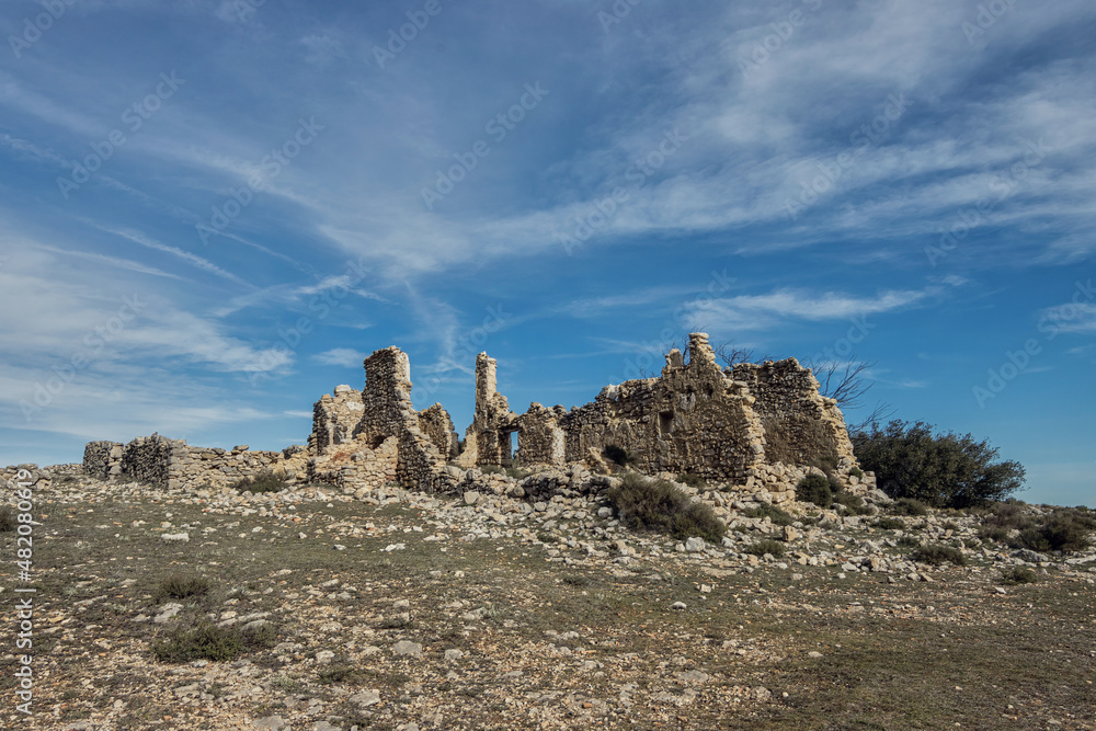 Ruins country house, damaged and abandoned by the passage of time in a valley under a blue sky