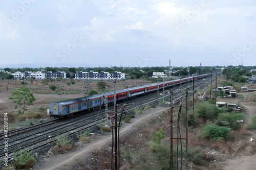 view of Indian Railways trains on the track and nearby electric poles.