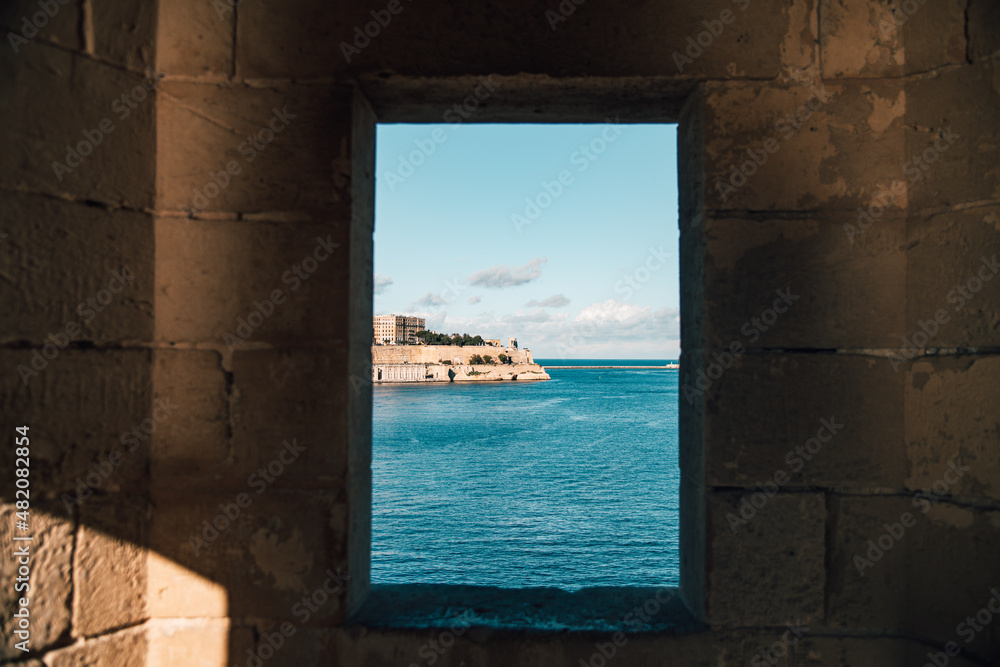The beautiful sea of ​​Malta through a window in the tower of a castle in Valleta.