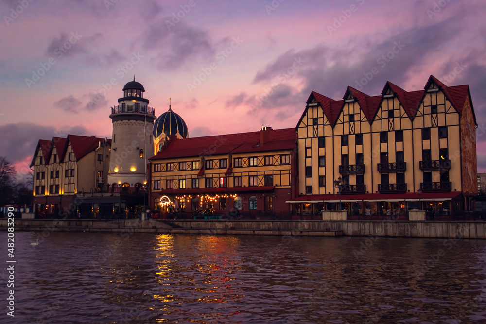 Obraz premium Fishing village in Kaliningrad at night. Stylization of ancient Europe, lighthouse, ancient houses.