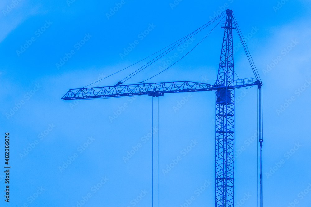 Tower crane against blue sky in cold winter weather work