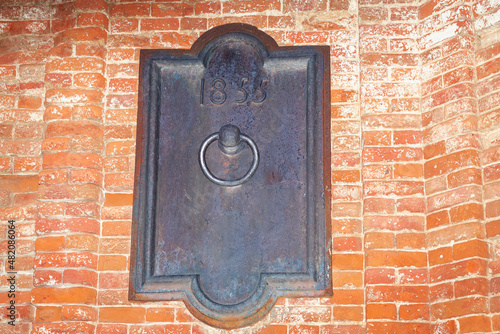 Antique metal plaque on an old brick wall.