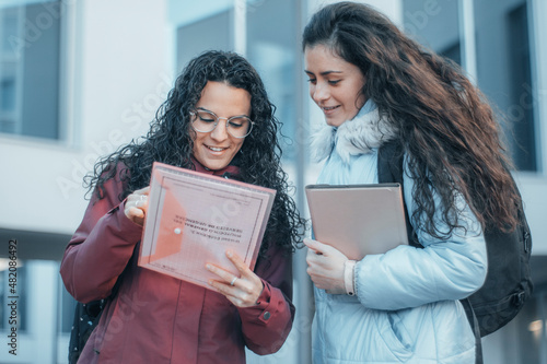 Chicas alumnas jovenes estudiando en el recreo de su universidad para realizar una tarea en clase