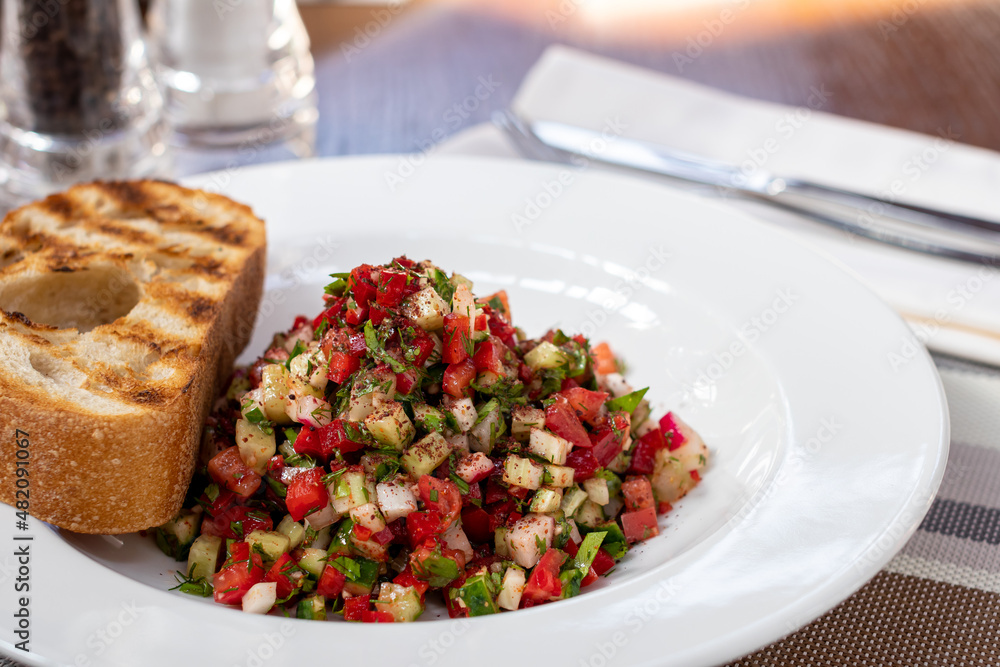 Israeli salsa salad with vegetables on a white plate Israeli salsa salad with vegetables on a white plate