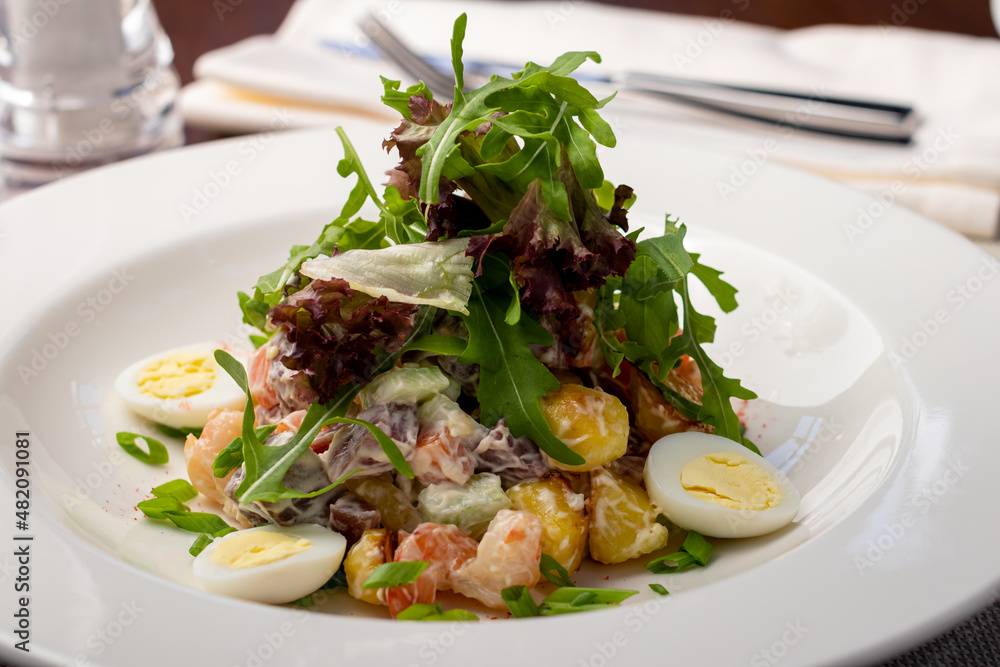 Olivier salad with shrimps on a white plate Olivier salad with shrimps on a white plate