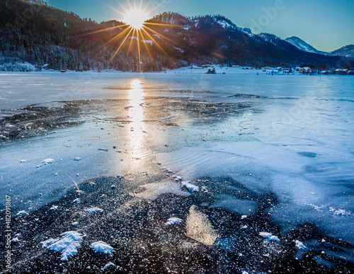 frozen alpine lake Weissensee at sunset  photo