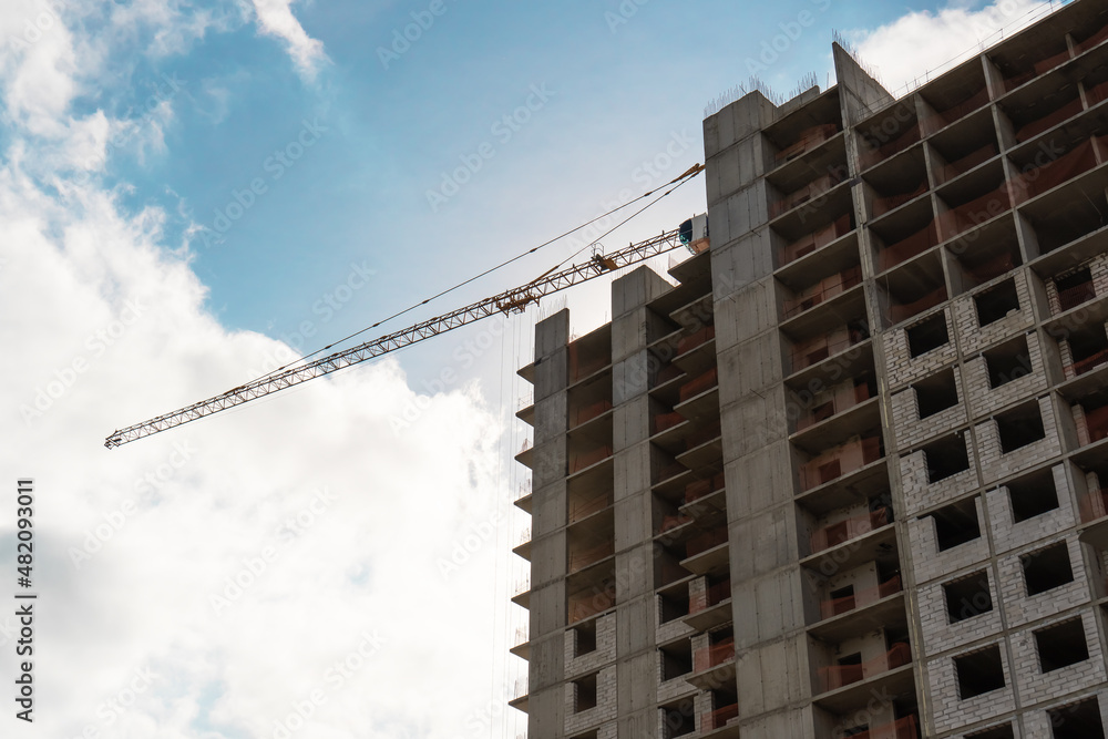 Tower crane at construction site during building construction.