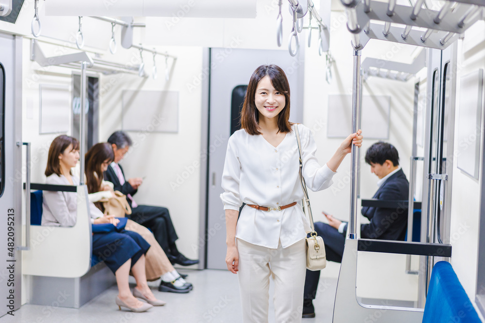 笑顔で電車に乗る若い女性 笑顔で電車に乗る若い女性