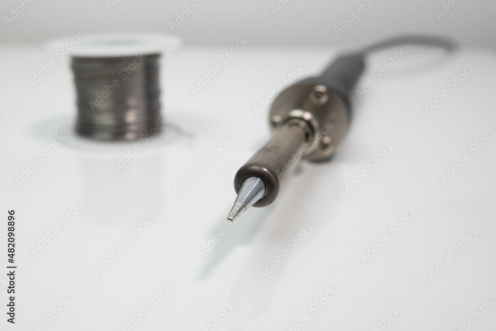 Soldering iron tip and solder wire. Close up, shallow depth of field with blurred background. Soldering iron tip and solder wire. Close up, shallow depth of field with blurred background.