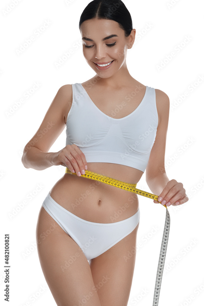 Young woman measuring waist with tape on white background Young woman measuring waist with tape on white background