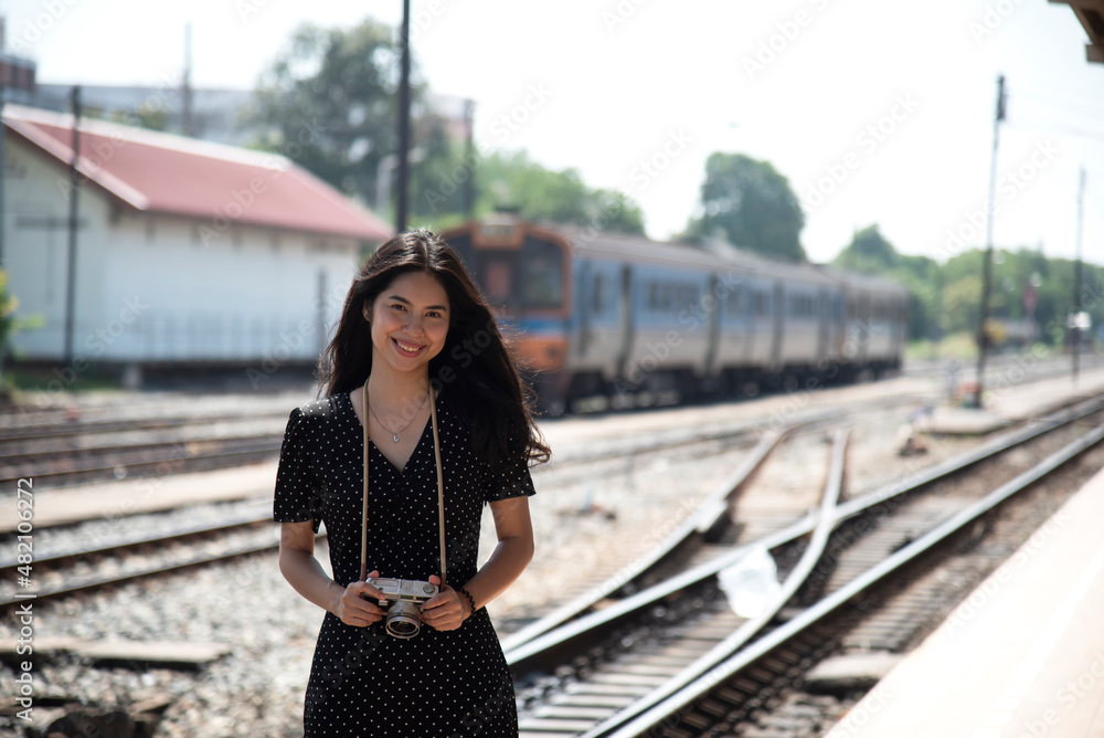 young asian woman smilingTraveler girl walking and waits train on railway platform
