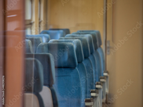 Selective blur on an  Interior of a EMU with Empty seats in an old intercity long didtance train train, European style, with typical comfortable blue seats...