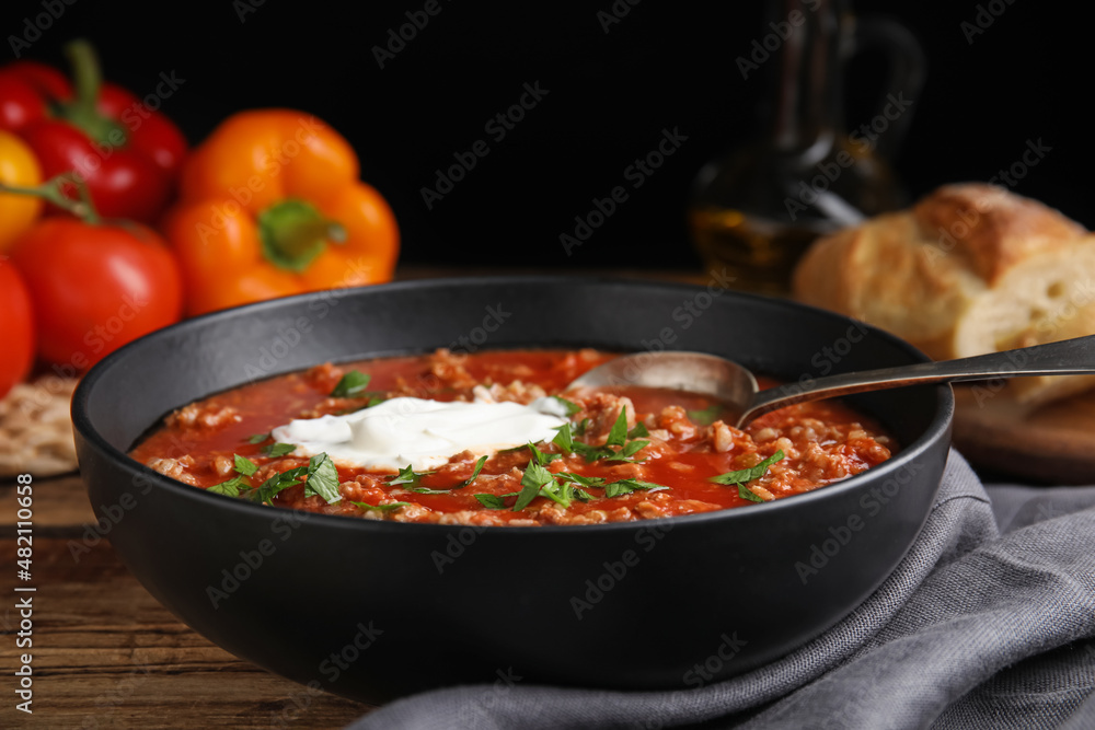 Bowl of delicious stuffed pepper soup on wooden table