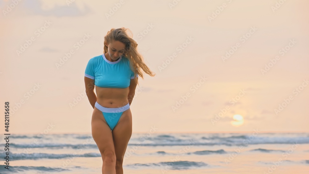 Woman standing on water sea. Girl stand in turquoise swimsuit. Freedom paradise holiday vacation summer beach, seaside landscape concept Woman standing on water sea. Girl stand in turquoise swimsuit. Freedom paradise holiday vacation summer beach, seaside landscape concept