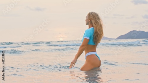 Woman standing on water sea. Girl stand in turquoise swimsuit. Freedom paradise holiday vacation summer beach, seaside landscape concept