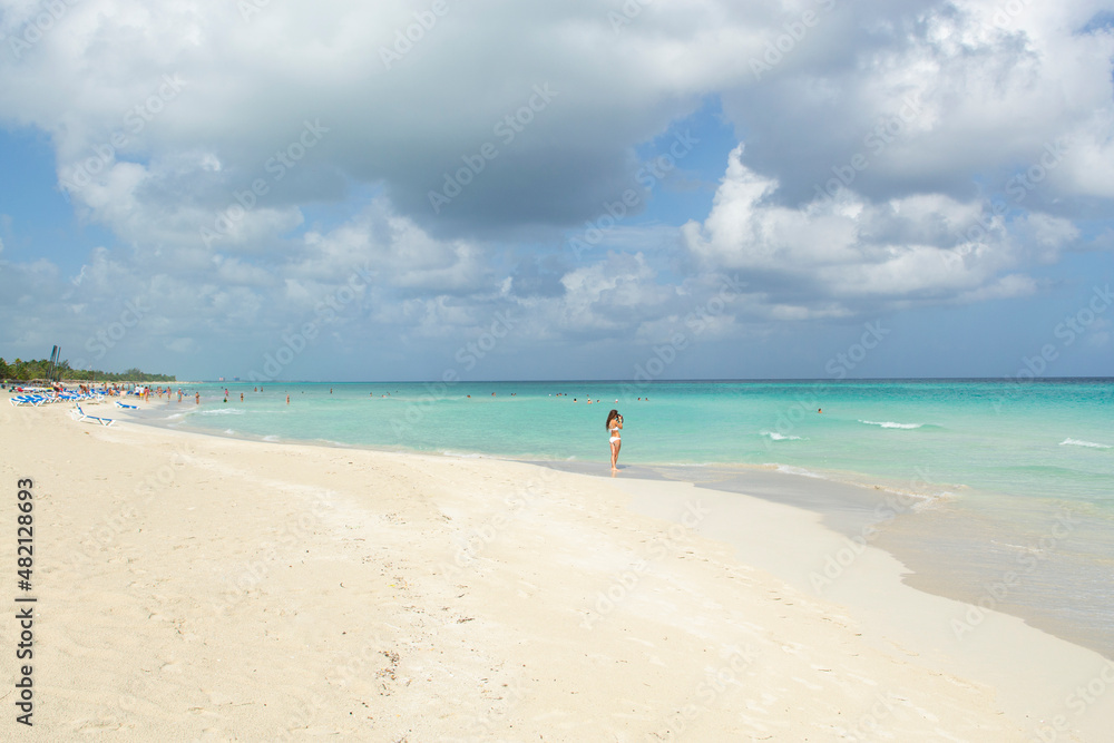 Wonderful white sandy beach, tourists and Caribbean sea,many dark clouds background, Varadero ,Cuba