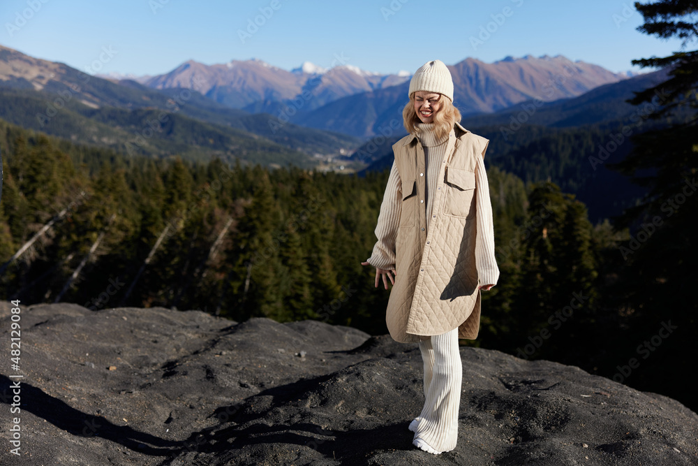 tourist in autumn clothes stands on a rock landscape blue sky relaxation tourist in autumn clothes stands on a rock landscape blue sky relaxation