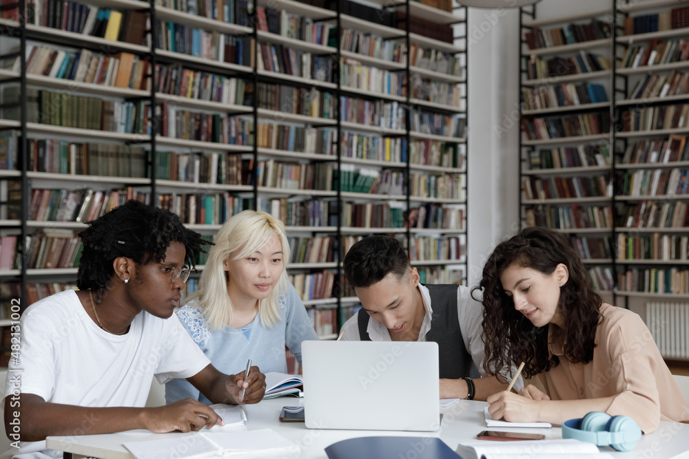 Multiethnic group of four gen Z university students working together at ...