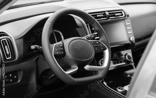Interior of the car interior. Steering wheel, instrument panel, computer screen, automatic transmission. Black and white photo