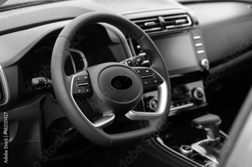 Interior of the car interior. Steering wheel, instrument panel, computer screen, automatic transmission. Black and white photo
