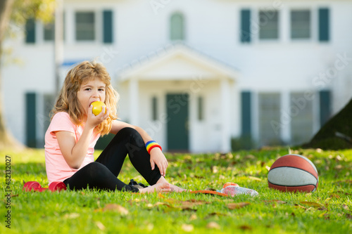 Kids relax on sport mat after sport exercises outdoor in park. Concept of children sport.