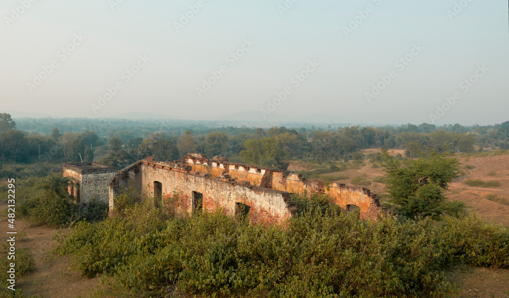 Eerie view of the damaged houses, with collapsing brick walls encroached by weeds, in totally abandoned state, at Simultala Rajbari in Bihar, India. These housed were used as pit latrine.