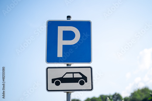 Blue and white parking lot sign with P letter and pictured car in the parking lot