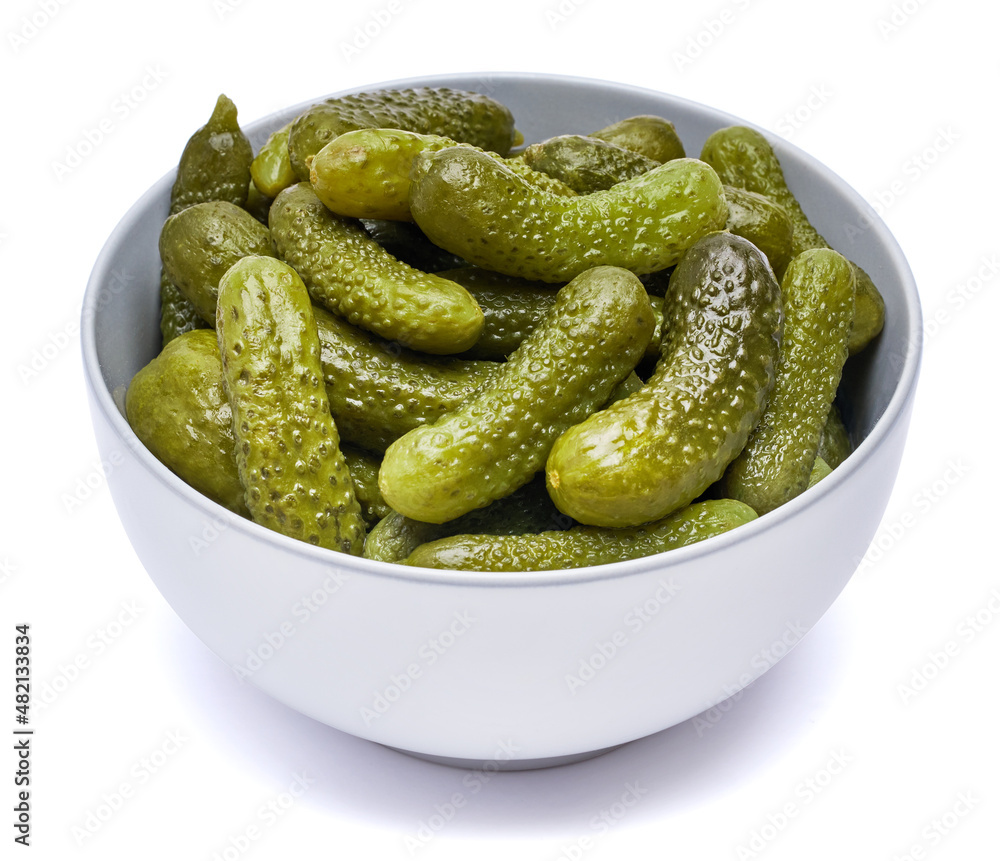 Plate of Tasty canned Whole green cornichons isolated on a white background Plate of Tasty canned Whole green cornichons isolated on a white background