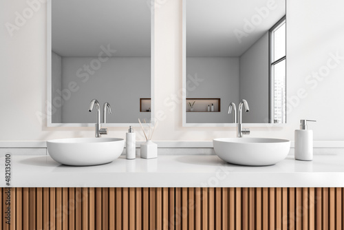 Bathroom interior with sink and mirror, accessories on white deck