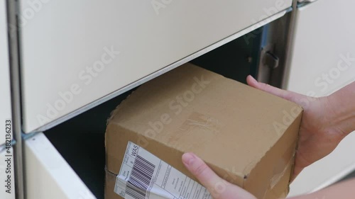 Taking out a parcel from a parcel locker in 4k slow motion 60fps