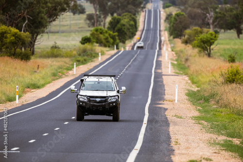Cars on a lonely, long, straight stretch of Australian highway. photo