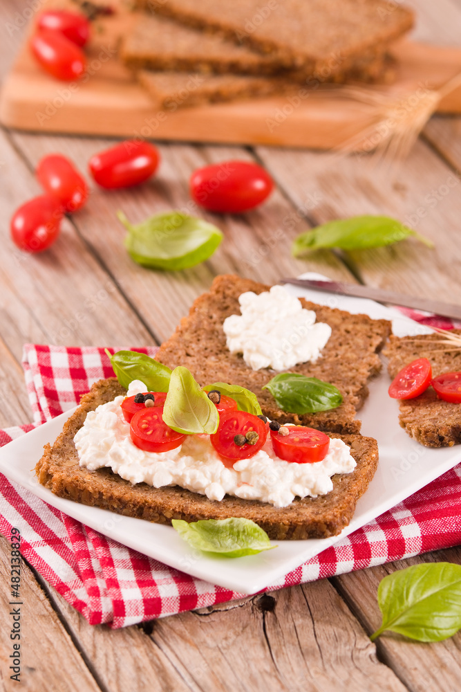 Rye bread with cottage cheese, basil and tomato.
