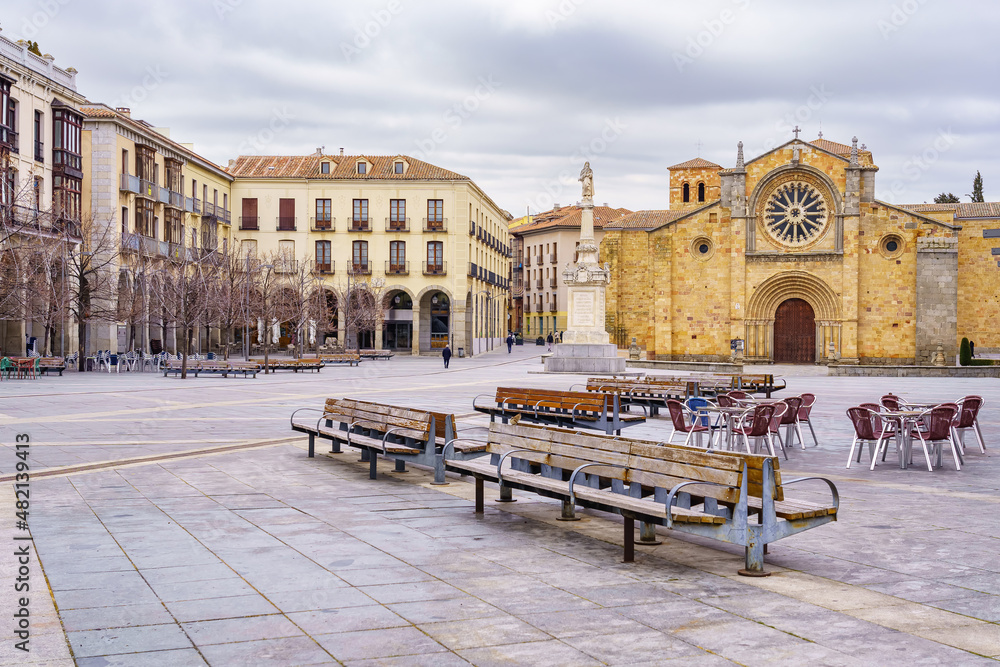 Obraz premium Large square with medieval church and old houses, benches to sit on, in the city of Avila, Spain.