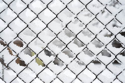 Fence net accumulated with snow, textural effect, background