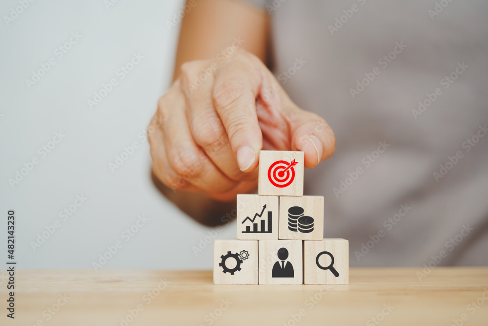 senior's hand holding dartboard icon on wood cube, the top of pyramid for business, planning strategy, goal, target concept senior's hand holding dartboard icon on wood cube, the top of pyramid for business, planning strategy, goal, target concept