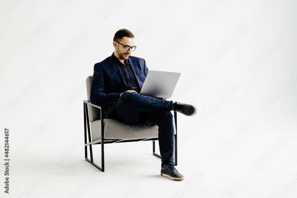 Smiling handsome businessman working with laptop over white background Smiling handsome businessman working with laptop over white background