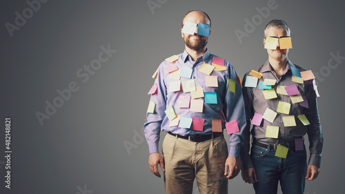Smiling businessmen covered with sticky notes photo