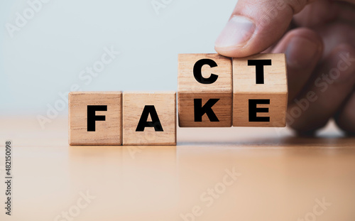 Hand flipping change fact to fake wording on wooden cube block for news of social media concept Fototapet