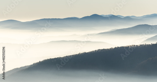 Silhouettes of mountains in the sea of fog in winter. © bios48