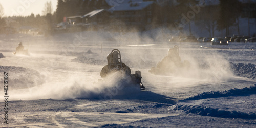 Ice karting action on sunny winter day. Motorsports racing activity in Finland.