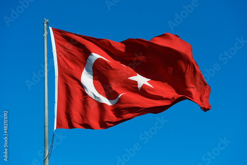 Turkish flag waving on the blue sky.