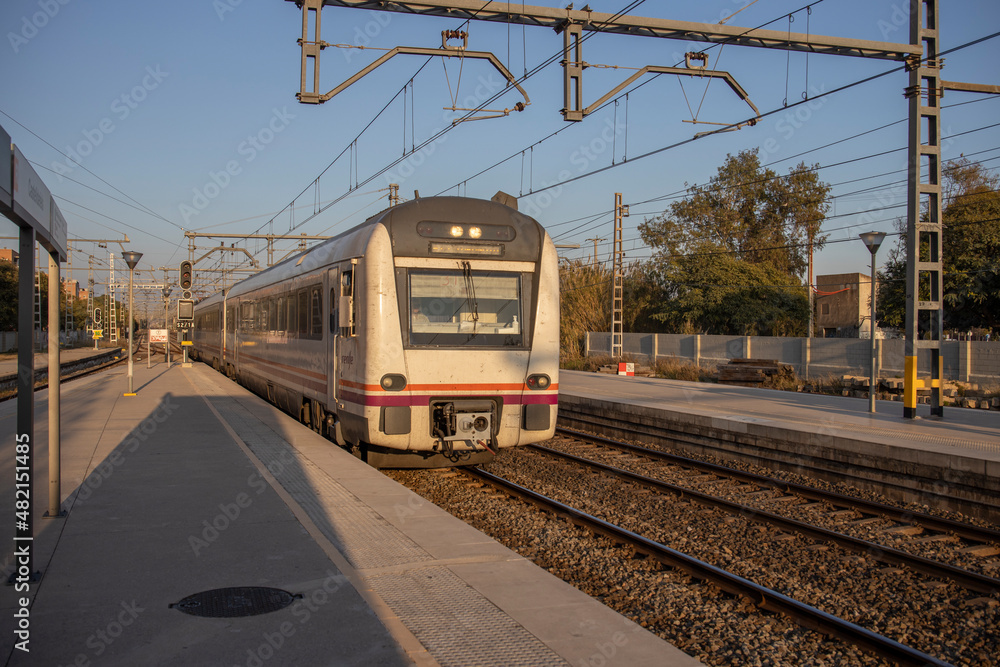 Obraz premium Passenger train in motion at the station in the evening. Rail travel. Modern intercity train on a railway platform. Passenger train on the railway in the evening.