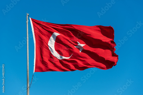 Turkish flag waving on the blue sky.