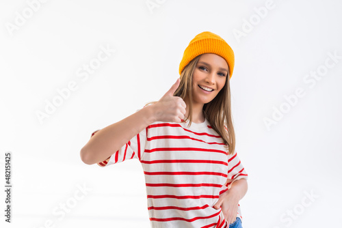 Smiling woman showing thumbs up and looking at the camera isolated over white background